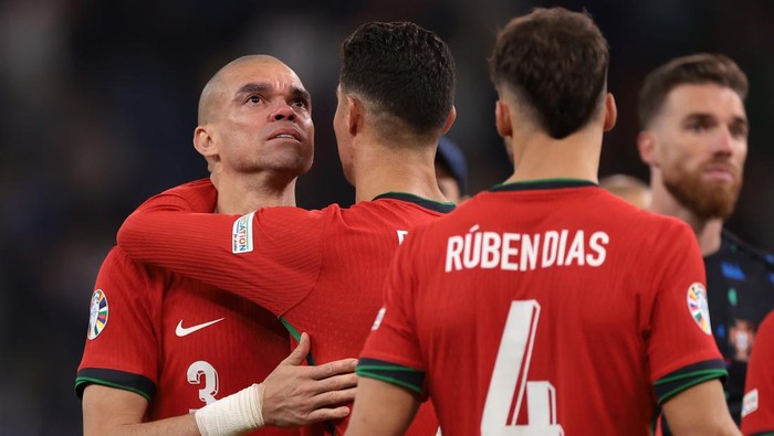 HAMBURG, GERMANY - JULY 05: Ruben Dias of Portugal looks on as Cristiano Ronaldo embraces an emotional Pepe following the penalty shoot out defeat in the UEFA EURO 2024 quarter-final match between Portugal and France at Volksparkstadion on July 05, 2024 in Hamburg, Germany. (Photo by Jonathan Moscrop/Getty Images)