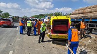 Sejumlah petugas kepolisian dan petugas Tol Kebomas melakukan evakuasi korban kecelaakaan yang melibatkan mobil elf dengan truk trailer bermuatan kayu gelondongan.