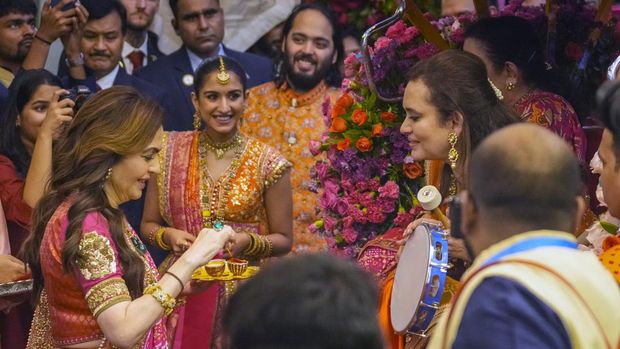 FILE - Nita Ambani, left, wife of Mukesh Ambani along with his son Anant Ambani, center right, and his fiancée Radhika Merchant, second left, greet guests during their pre-wedding ceremony at their residence in Mumbai, India, Wednesday, July 3, 2024.(AP Photo/Rafiq Maqbool, File)