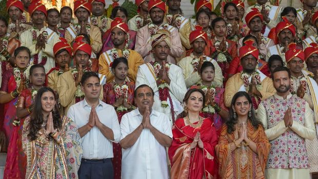 FILE - Chairman of Reliance Industries Limited Mukesh Ambani, third left, poses with his family members and underprivileged couples during a mass wedding organized by him as the part of pre-wedding celebrations of his youngest son, Anant Ambani, in Mumbai, India, Tuesday, July 2, 2024. (AP Photo/Rafiq Maqbool, File)