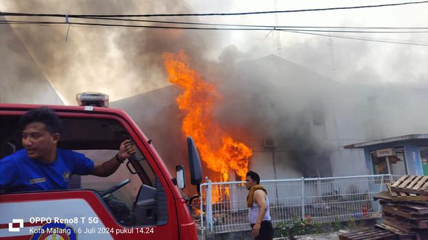 Petugas PMK memadamkan api yang menghanguskan gudang perabot rumah tangga di Kota Malang.