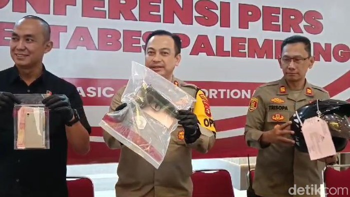 Polisi menunjukkan barang bukti pistol mainan yang digunakan tersangka.