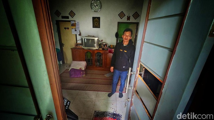 Ramlan menunjukan pintu rumah yang dijebol oleh Mustopa alis Opa penderita gangguan jiw ayang menyerang ayahnya Sabtu (6/7/2024) pagi tadi.