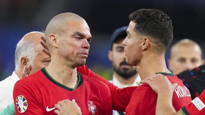 HAMBURG, GERMANY - JULY 5: Portugals forward Cristiano Ronaldo (R) comforts Portugals defender Pepe (L) following Theo Hernandezs penalty gives victory to France in the UEFA Euro 2024 quarter-final football match between Portugal and France at the Volksparkstadion in Hamburg on July 5, 2024. (Photo by Emin Sansar/Anadolu via Getty Images)
