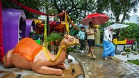 Hujan tak menyurutkan warga untuk berkunjung ke pameran Flona 2024. Mereka datang dengan memakai payung agar terhindar dari guyuran hujan. 