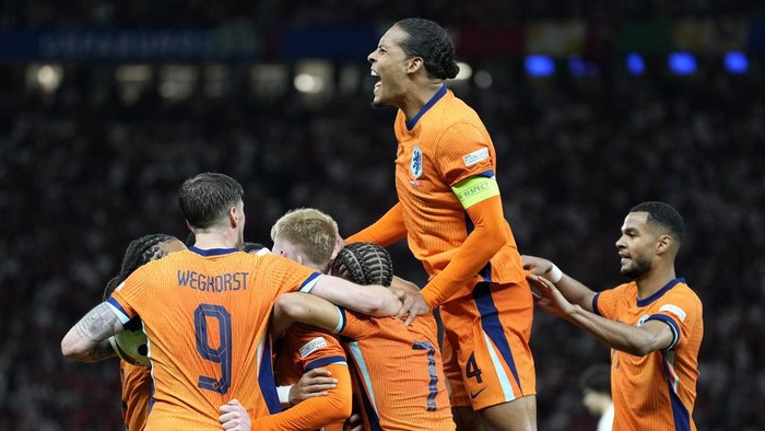 Virgil van Dijk of the Netherlands, up, celebrates after Stefan de Vrij of the Netherlands scored their sides first goal during a quarterfinal match between the Netherlands and Turkey at the Euro 2024 soccer tournament in Berlin, Germany, Saturday, July 6, 2024. (AP Photo/Antonio Calanni)