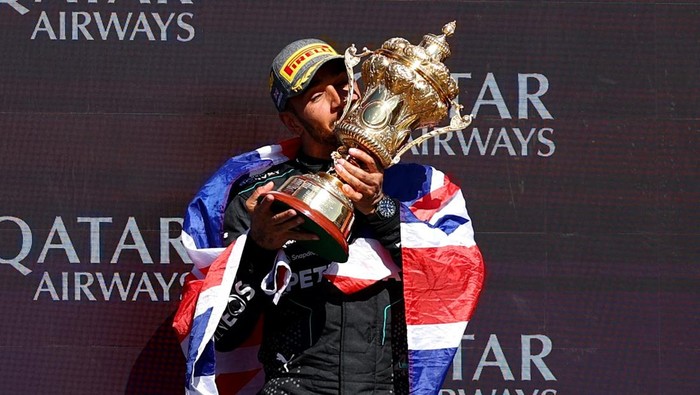 Formula One F1 - British Grand Prix - Silverstone Circuit, Silverstone, Britain - July 7, 2024 Mercedes Lewis Hamilton celebrates with a trophy on the podium after winning the British Grand Prix REUTERS/Andrew Boyers