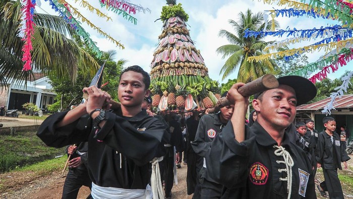Peserta pawai Grebeg Suro mengarak tumpengan di Sridadi, Batanghari, Jambi, Minggu (7/7/2024). Kegiatan tahunan yang dilakukan secara swadaya yang diikuti sekitar dua ribu peserta dari perwakilan 25 RT setempat tersebut dalam rangka menyambut masuknya bulan Suro dalam penanggalan Jawa atau bulan Muharam dalam penanggalan Islam. ANTARA FOTO/Wahdi Septiawan/tom.