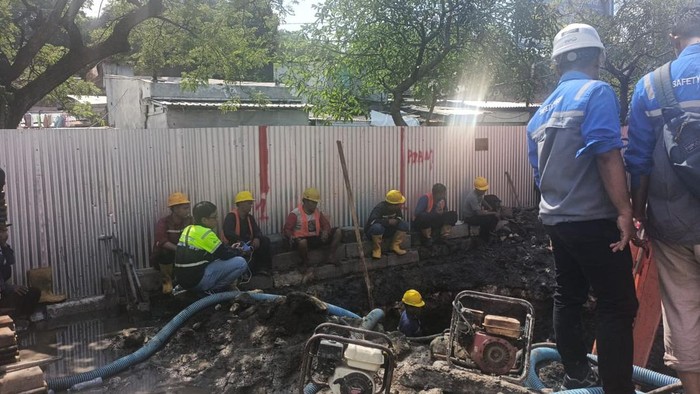 Petugas memperbaiki pipa PDAM yang bocor