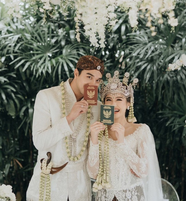 Keduanya tampil kompak mengenakan busana pengantin adat Sunda berwarna putih untuk akad nikah. Usai resmi menjadi pasangan suami-istri, keduanya pun langsung berpose memamerkan buku nikah mereka. Foto: Instagram/@salshabillaadr