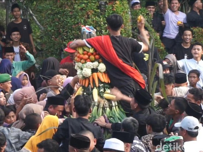 Warga berebut gunungan dalam Grebeg Suro di Dukuh Girikusumo, Banyumeneng, Mranggen, Demak, Minggu (7/7/2024).