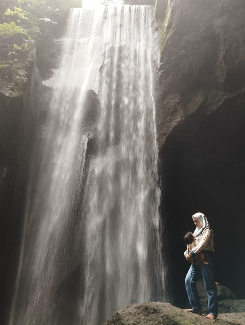 Wisatawan Berfoto di air terjun Goa Rajo, Bangli, Bali, beberapa waktu lalu.