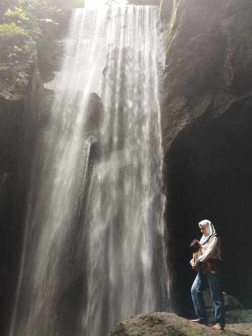 Wisatawan Berfoto di air terjun Goa Rajo, Bangli, Bali, beberapa waktu lalu.
