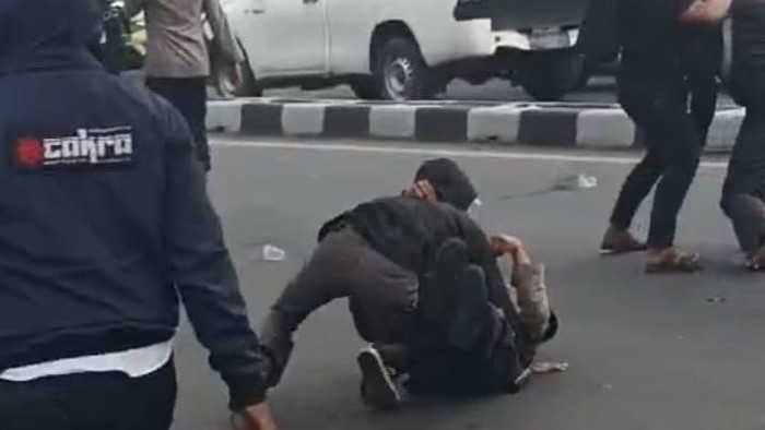 Anggota polisi terjatuh saat bubarkan pengunjuk rasa di depan kampus Unismuh.