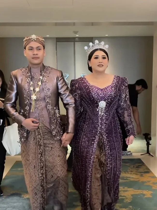 Untuk acara resepsi Clarissa dan Sandro memilih mengenakan warna ungu tua. Terlihat resepsi pernikahan tersebut juga masih kental dengan adat Jawa. Foto: Instagram/@askyfebrianti