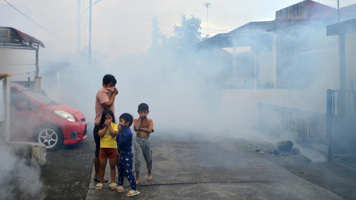 Warga menutup hidung mereka saat pengasapan (fogging) nyamuk Demam Berdarah Dengue (DBD) di Kayu Kalek Padang, Sumatera Barat, Senin (8/7/2024). Dinas Kesehatan Kota Padang melakukan pengasapan berdasarkan laporan kasus warga yang terkena DBD dalam rangka memutus penularan penyakit tersebut. ANTARA FOTO/Iggoy el Fitra/rwa.