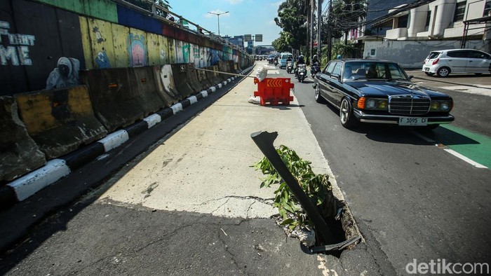 Pengendara yang melintas di Jalan Kampung Melayu Besar, Tebet, Jakarta, harap berhati-hati, Senin (8/7/2024). Ada lubang di tengah jalan tersebut.