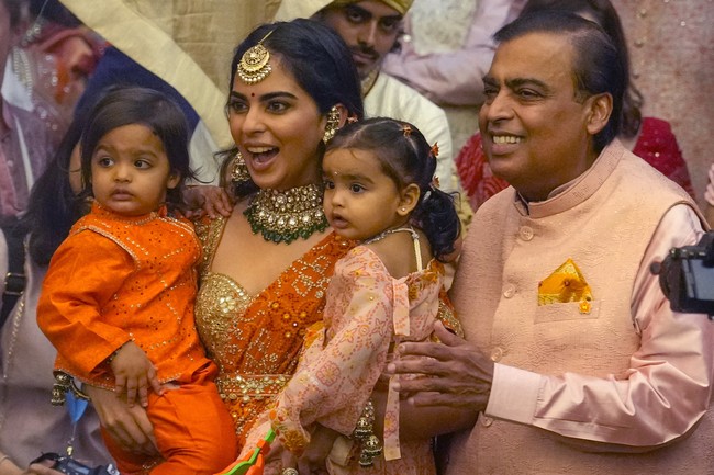 Ekspresi bahagia menghiasi wajah Mukesh Ambani (kanan), ayah mempelai pria. Ia tampak bersama putrinya, Isha Ambani, dan kedua cucunya. Dengan harta yang tercatat bernilai US$ 116 miliar, pria 66 tahun itu menempati urutan ke-9 orang terkaya di dunia dan pertama di kawasan Asia menurut Forbes. (Foto: AP Photo/Rafiq Maqbool)