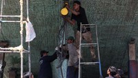 Para buruh harian ini tanpa masker dan alat pengaman memperbaiki dan mempercantik kapal tua.  
