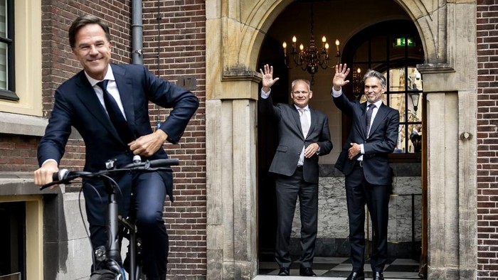 Newly-appointed Dutch Prime Minister Dick Schoof (R) waves to former Prime Minister Mark Rutte (L) leaving on his bike after a handover ceremony at the Torentje in The Hague, on July 2, 2024. Former spy chief Dick Schoof becomes the new Dutch prime minister on July 2, leading a right-wing coalition cabinet on a mission to implement the 