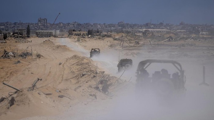 Israeli army vehicles transport a group of soldiers and journalists inside the southern Gaza Strip, Wednesday, July 3, 2024. The Israeli military invited reporters for a tour of Rafah, where the military has been operating since May 6. (AP Photo/Ohad Zwigenberg, Pool)