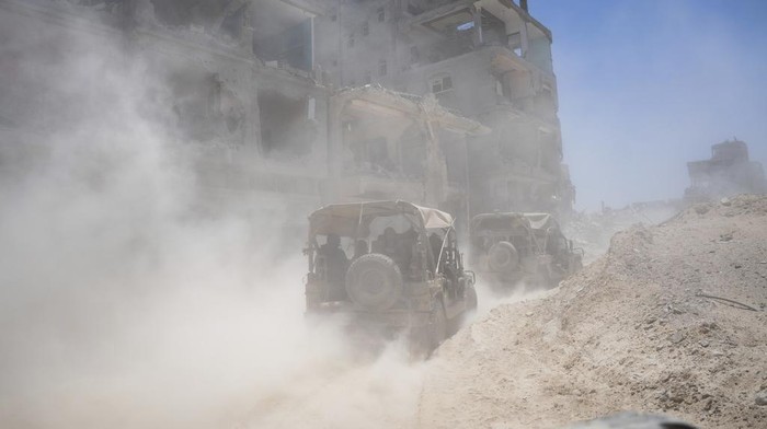 Penampakan Rafah Bak Kota Hantu, Dipenuhi Puing-Tertutup Debu Israeli army vehicles transport a group of soldiers and journalists inside the southern Gaza Strip, Wednesday, July 3, 2024. The Israeli military invited reporters for a tour of Rafah, where the military has been operating since May 6. (AP Photo/Ohad Zwigenberg, Pool)
