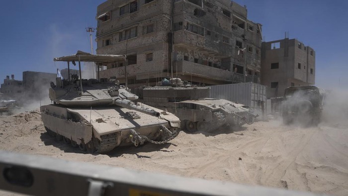 Penampakan Rafah Bak Kota Hantu, Dipenuhi Puing-Tertutup Debu Israeli army vehicles transport a group of soldiers and journalists inside the southern Gaza Strip, Wednesday, July 3, 2024. The Israeli military invited reporters for a tour of Rafah, where the military has been operating since May 6. (AP Photo/Ohad Zwigenberg, Pool)