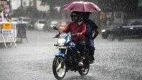 Tak hanya pejalan kaki, pemotor yang berboncengan pun mengenakan payung.