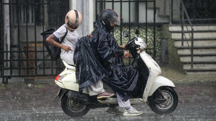 Hujan lebat tengah mengguyur Kolkata, India. Para pengendara nekat menerobos hujan.