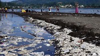 Sejumlah pengunjung berwisata di Pantai Manakarra yang dipenuhi sampah, Minggu (7/7/2024).