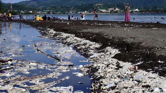 Dua anak bermain di kawasan pantai yang dipenuhi sampah di Pantai Manakarra, Mamuju, Sulawesi Barat, Minggu (7/7/2024). Tumpukan sampah yang didominasi sampah plastik tersebut mencemari kawasan objek wisata sehingga mengganggu kenyamanan wisatawan. ANTARA FOTO/Akbar Tado/YU