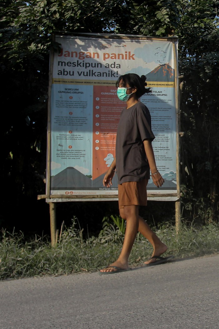 Dampak erupsi Gunung Lewotobi Laki-laki Warga berjalan di depan baliho informasi tentang dampak abu vulkanik di Desa Wolorona, Kabupaten Flores Timur, Nusa Tenggara Timur (NTT), Selasa (9/7/2024). Erupsi Gunung Lewotobi Laki-laki pada Selasa (9/7) pukul 11:33 WITA dengan tinggi kolom abu teramati 900 meter di atas puncak (2.248 meter di atas permukaan laut) menyebabkan sejumlah desa di Kabupaten Flores Timur dan Kabupaten Sikka terdampak hujan abu, sementara itu gunung tersebut saat ini masih menunjukkan peningkatan aktivitas dan berstatus Siaga level III. ANTARA FOTO/Mega Tokan/sgd/aww.