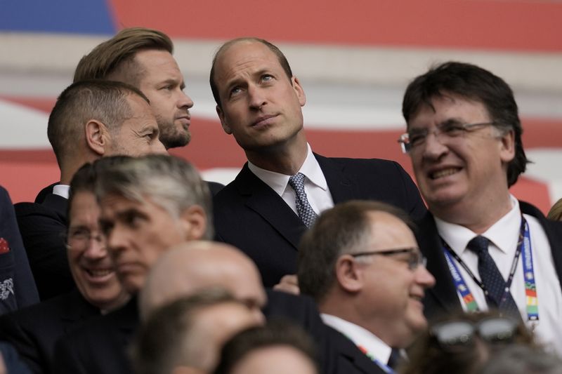 Britain's Prince William, center, waits for the start of the quarterfinal match between England and Switzerland at the Euro 2024 soccer tournament in Duesseldorf, Germany, Saturday, July 6, 2024. (AP Photo/Thanassis Stavrakis)