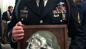 Seorang tentara dan helmnya yang menyelamatkannya di medan laga. Ia selamat walau ditembak di kepala. Foto: Bored Panda