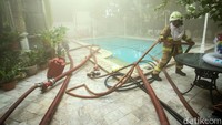 Petugas juga menggunakan air dari kolam renang yang ada di dalam rumah.