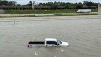Mobil tersebut mengambang mengikuti arus banjir. AP Photo/Juan A Lozano.  