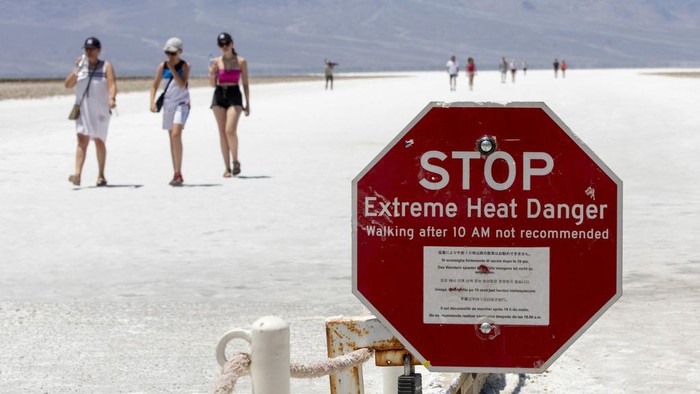 Tourists take photos in front of the Furnace Creek visitor center thermometer Monday, July 8, 2024, in Death Valley National Park, Calif.  (Daniel Jacobi II/Las Vegas Review-Journal via AP)