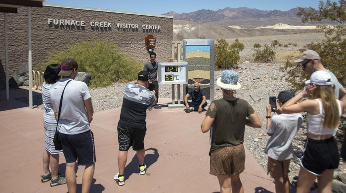 Wisatawan Ramai ke Lembah Kematian Saat Cuaca Lagi Panas-panasnya Tourists take photos in front of the Furnace Creek visitor center thermometer Monday, July 8, 2024, in Death Valley National Park, Calif. (Daniel Jacobi II/Las Vegas Review-Journal via AP)