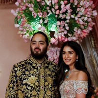 Tidak kalah menarik, calon istrinya, Radhika Merchant, juga mengenakan busana dari Abu Jani Sandeep Khosla. Dia tampil menawan dengan lehenga (sari) berpanel yang terinspirasi dari lampu gantung. Busana tersebut dihiasi kristal Swarovski, dan blouse off-shoulder dengan dupatta (selendang) hijau pistachio yang disampirkan di lengannya. Foto: dok. Getty Images