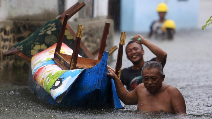 Banjir Luapan Danau Limboto Dua warga menyelamatkan ayam peliharaan mereka ketika banjir merendam Desa Buhu, Kecamatan Telaga jaya, Kabupaten Gorontalo, Gorontalo, Rabu (10/7/2024). Dua desa yaitu Buhu dan Hutadaa terendam air luapan Danau Limboto hingga ketinggian mencapai 1,5 meter akibat hujan deras mengguyur daerah itu. ANTARA FOTO/Adiwinata Solihin/Spt.