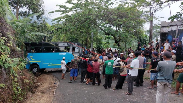Warga gotong royong saat membalikan truk yang terguling di Desa Kemuning, Kecamatan Ngargoyoso, Karanganyar, Rabu (10/7/2024).