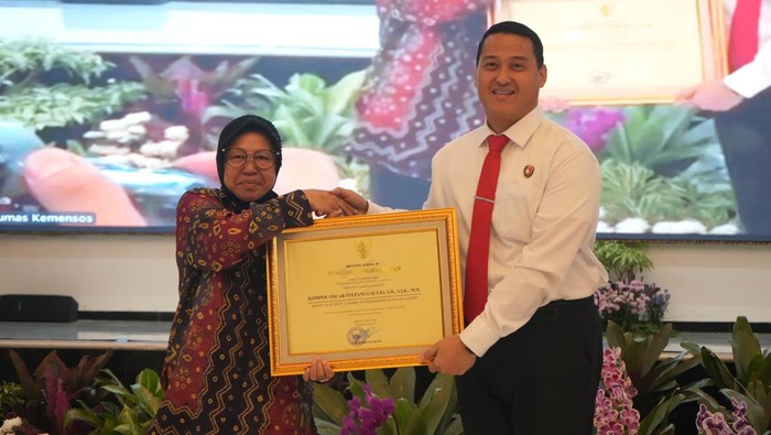Dirreskrimsus Polda Jatim Kombes Luthfie Sulistiawan menerima penghargaan dari Mensos Risma.