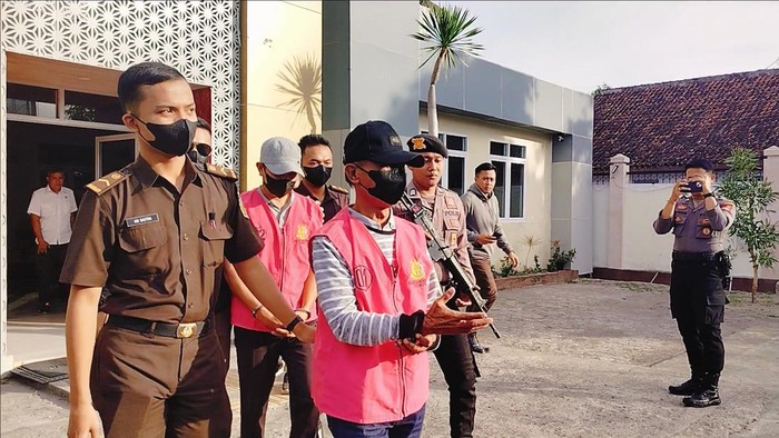 Eks Kepala Desa Riwo berinisial AR (bertopi hitam) dan mantan Bendahara Desa Riwo, SY (bertopi abu-abu), saat digiring petugas menuju Lapas Dompu, Rabu (10/7/2024) sore. (Faruk Nickyrawi/detikBali)