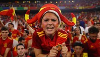 Wanita ini menunjukkan lambang yang ada di bajunya usai timnas lanjut ke babak final. REUTERS/Leonhard Simon