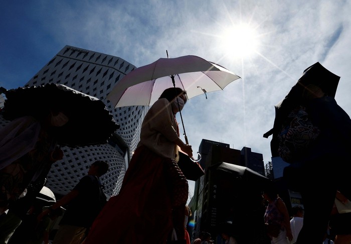 Passersby take a break under a cooling mist as the Japanese government issued a heatstroke alert in Tokyo and other prefectures, in Tokyo, Japan July 9, 2024. REUTERS/Issei Kato