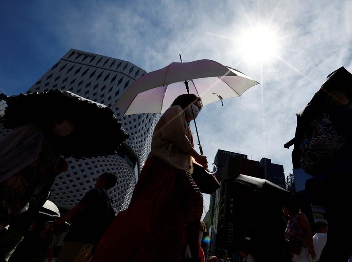 Passersby take a break under a cooling mist as the Japanese government issued a heatstroke alert in Tokyo and other prefectures, in Tokyo, Japan July 9, 2024. REUTERS/Issei Kato