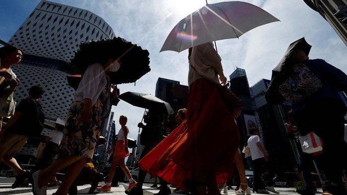 Passersby take a break under a cooling mist as the Japanese government issued a heatstroke alert in Tokyo and other prefectures, in Tokyo, Japan July 9, 2024. REUTERS/Issei Kato