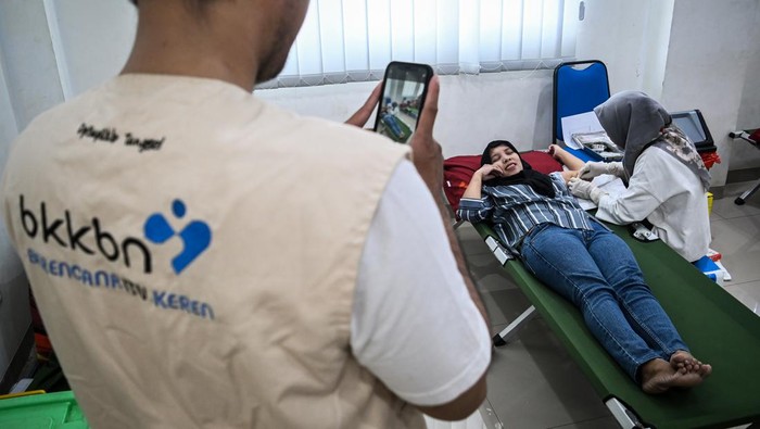 Petugas kesehatan memasangkan alat kontrasepsi jenis KB implan kepada akseptor di Kantor Kelurahan Bakti Jaya, Setu, Tangerang Selatan, Banten, Rabu (10/7/2024). Dinas Pemberdayaan Perempuan Perlindungan Anak Pengendalian Penduduk dan Keluarga Berencana (DP3AP2KB) Kota Tangerang Selatan melaksanakan layanan Safari Keluarga Berencana (KB) guna meningkatkan kesertaan penggunaan metode kontrasepsi jangka panjang pada wanita berupa implan dan Intrauterine Device (IUD). ANTARA FOTO/Sulthony Hasanuddin/tom.