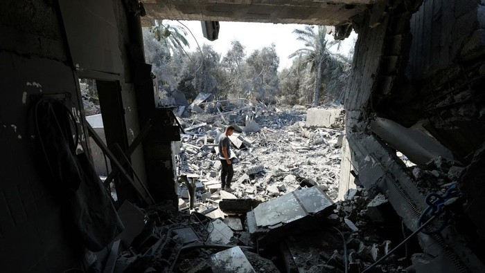 A Palestinian youth stands amid the rubble of a house destroyed in an Israeli strike, amid the Israel-Hamas conflict, in Nusairat refugee camp, in the central Gaza Strip, July 9, 2024. REUTERS/Ramadan Abed     TPX IMAGES OF THE DAY