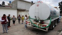 Seorang petugas menyiapkan selang air dari truk untuk disalurkan kepada warga di Meksiko, Selasa (9/10/2024).